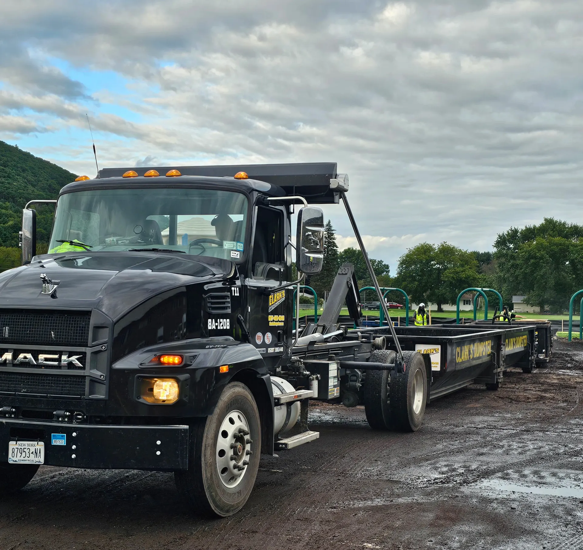 A black mack truck is parked in the mud