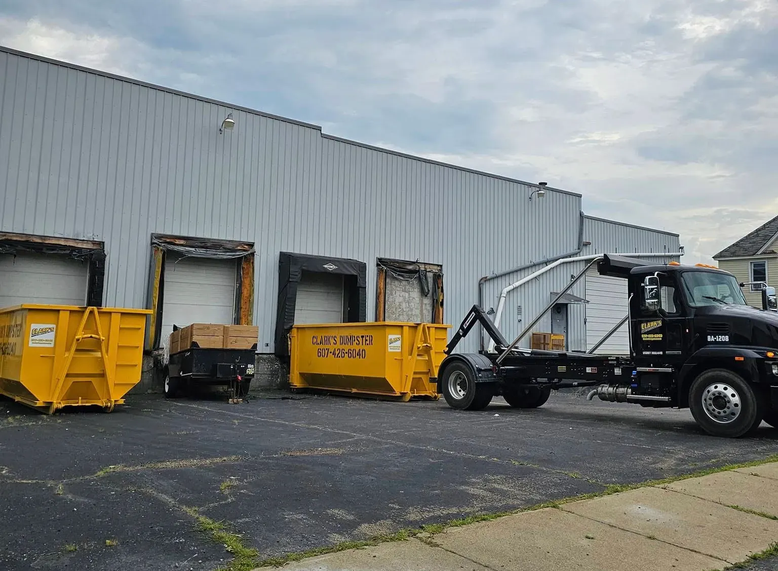 A dumpster truck is parked in front of a building.