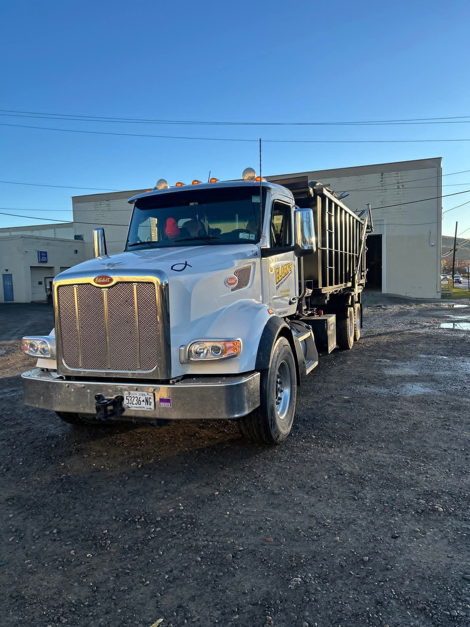 Clark's residential trash pickup truck collecting bagged household trash in Elmira, NY