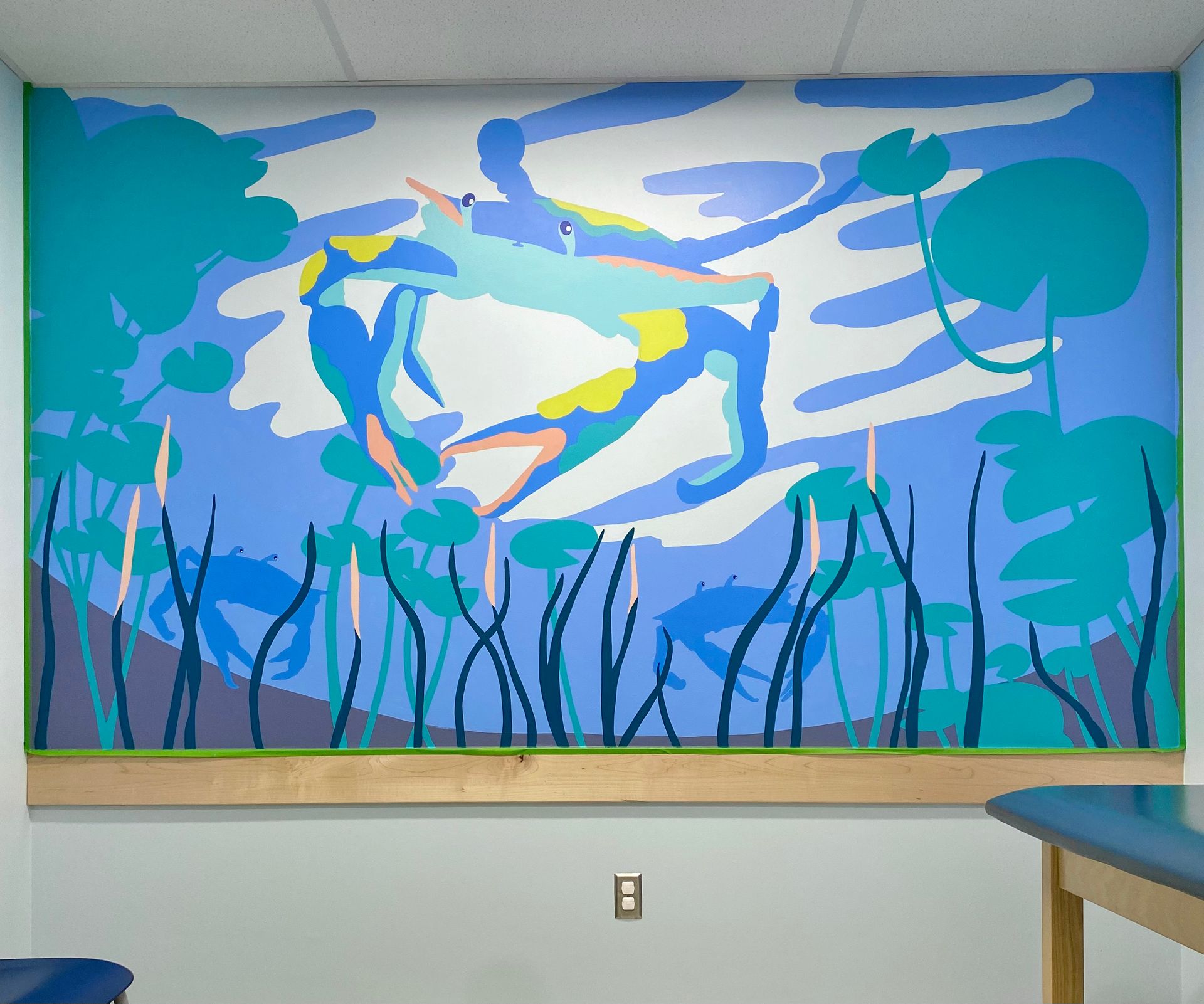 Blue crab mural with lily pads above a pediatric exam table, Austin