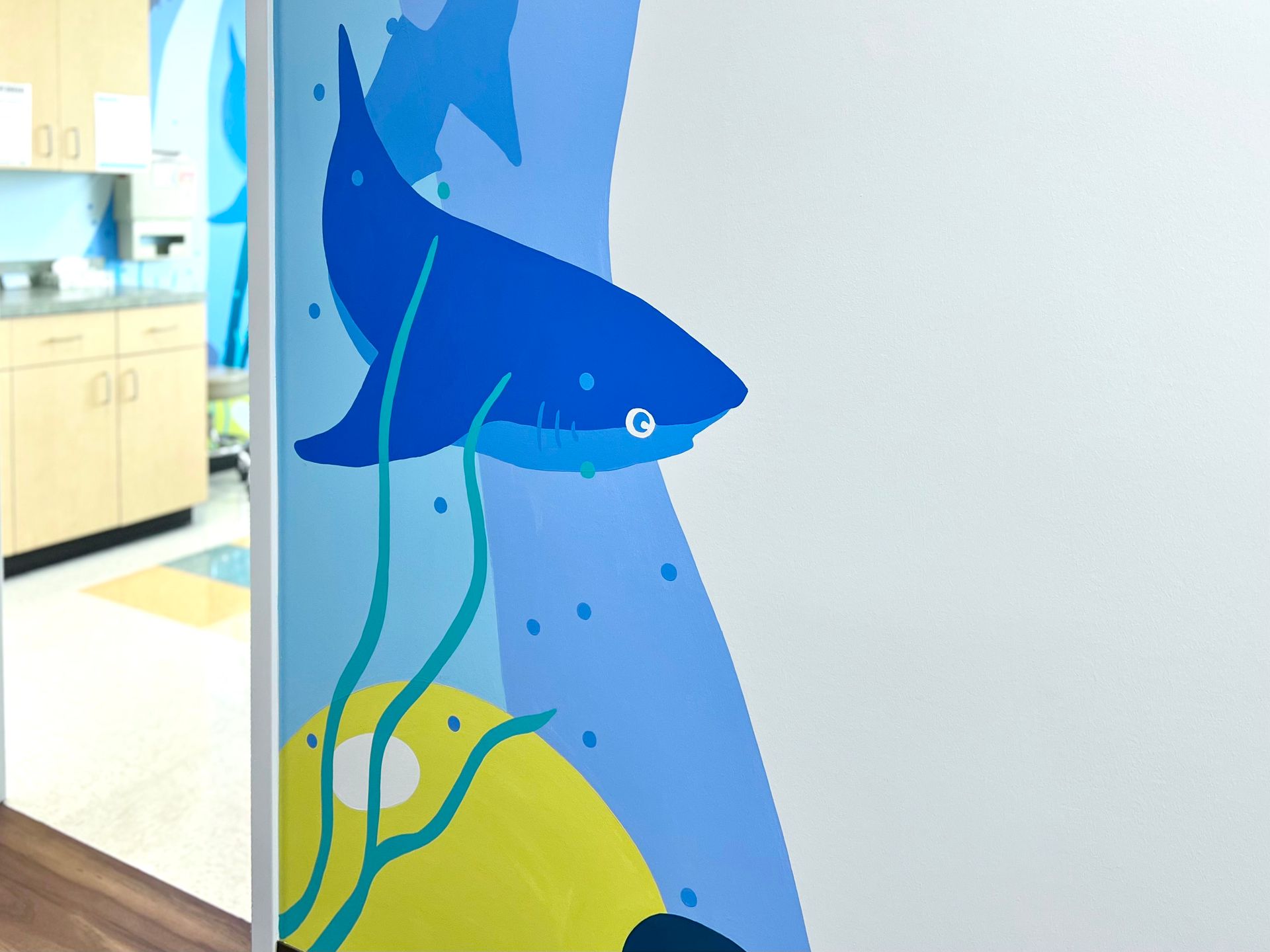 Shark mural wrapping around a doorway in a children's medical office