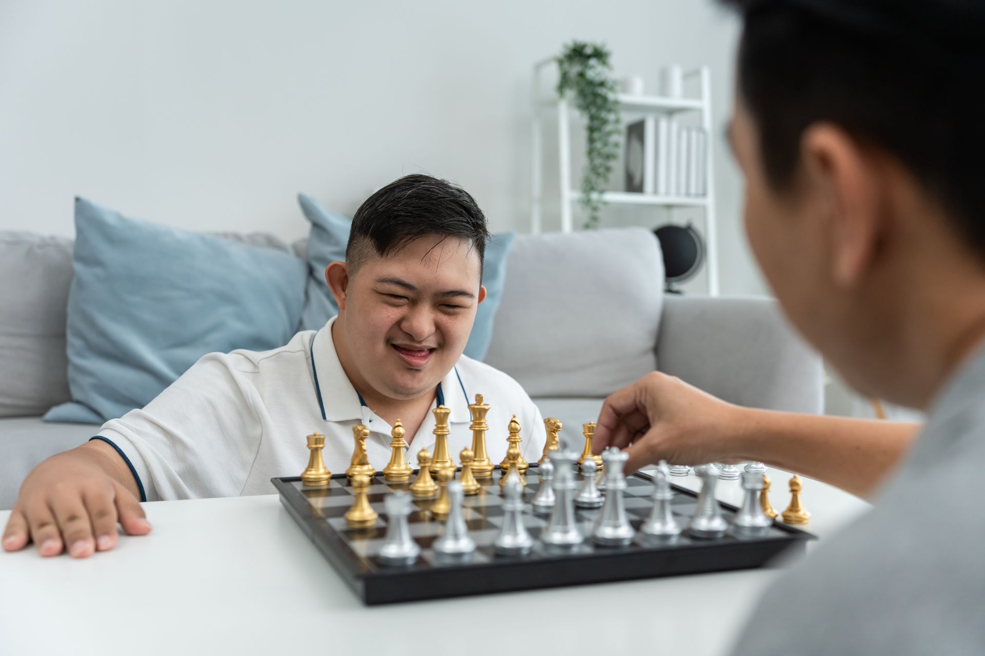 Two people concentrating on a chess game at a park table