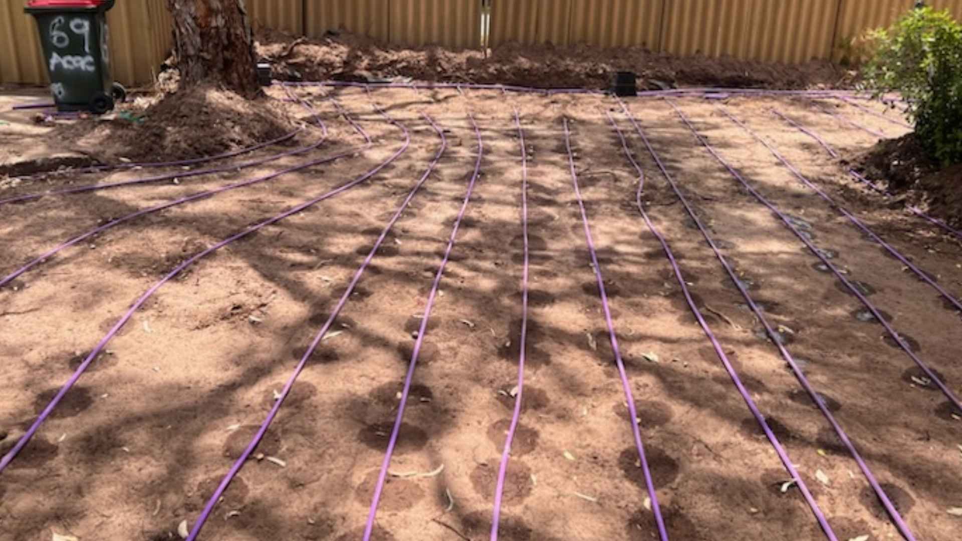 Grey septic tank lid in a soil trench.