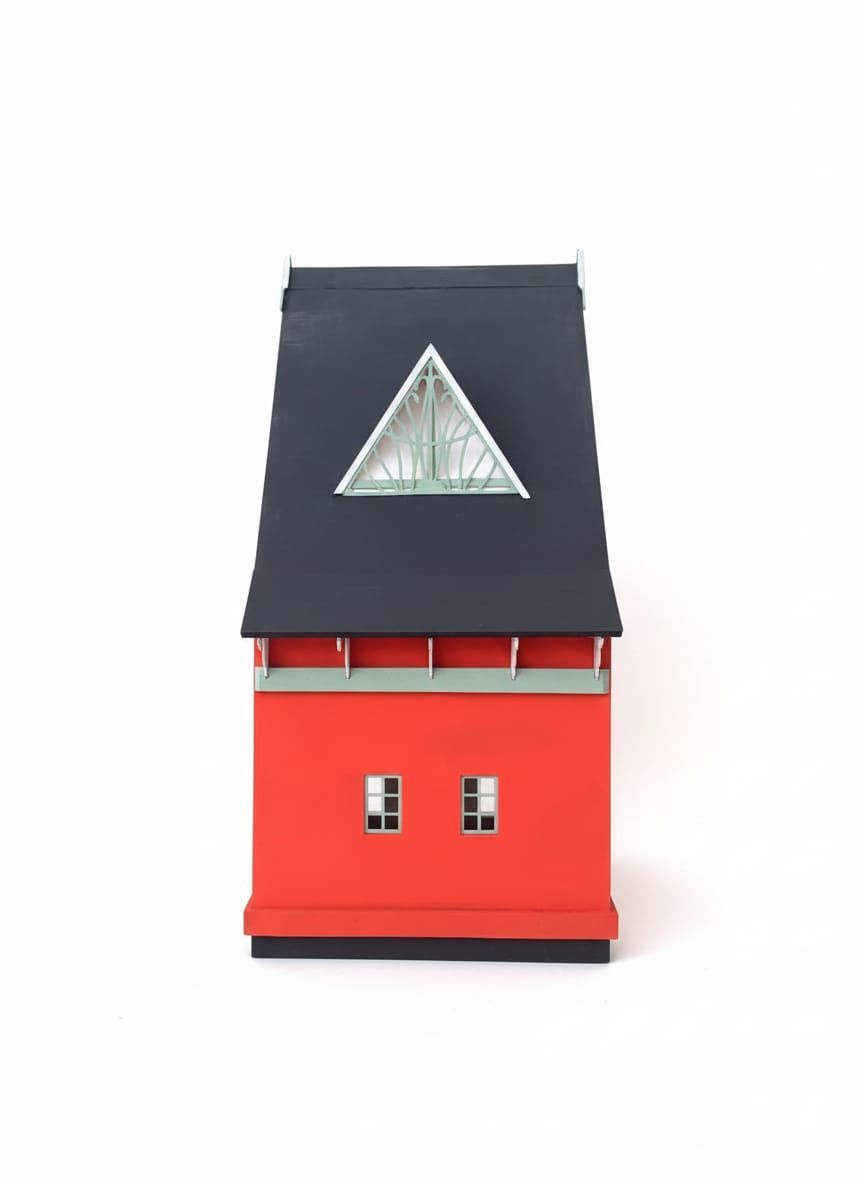 Modelo de edificio rojo y negro con una ventana triangular en el techo, dos ventanas cuadradas y fondo blanco.