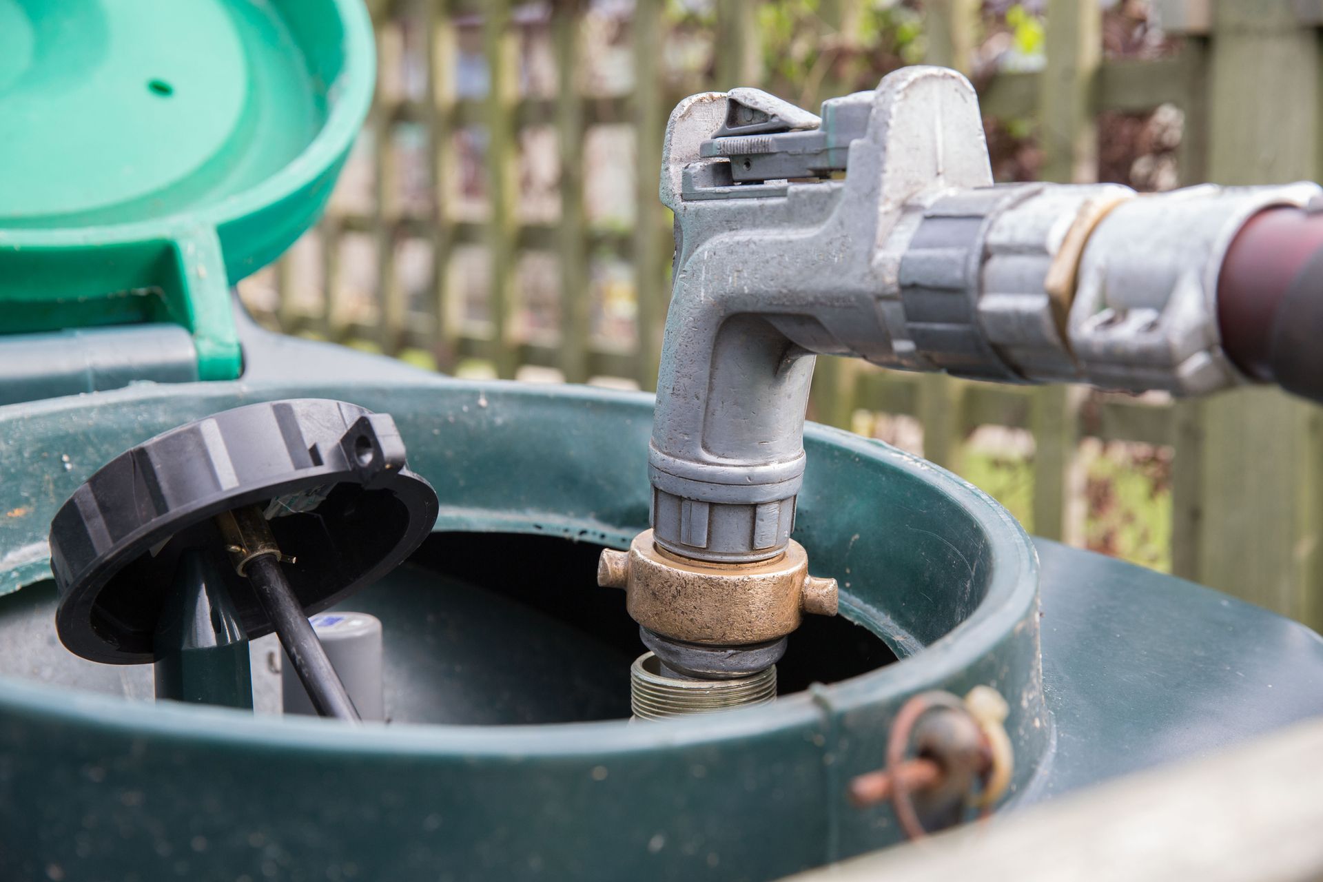 Fuel tank filling nozzle connected to outdoor oil storage container during fuel delivery.