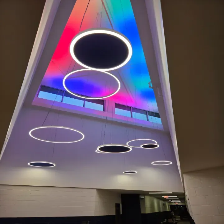 Modern atrium ceiling with glowing circular lights and colorful red-blue LED panels