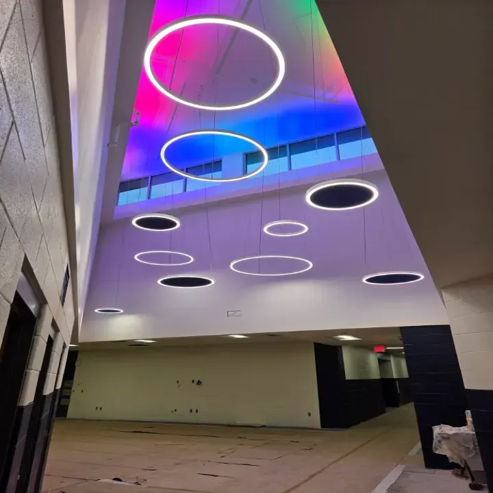 Modern atrium ceiling with glowing circular lights and colorful purple-blue ambient lighting
