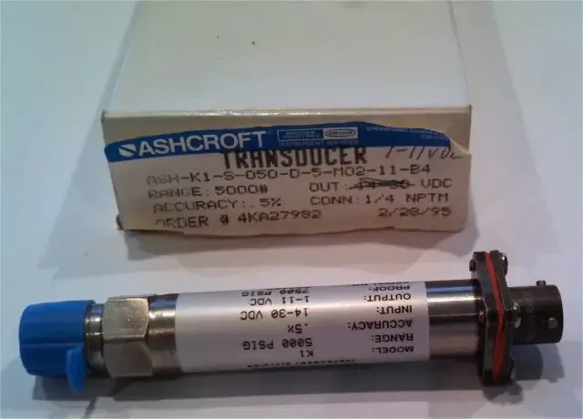 Metal cylindrical sensor with blue cap, shown beside its cardboard box on a white surface