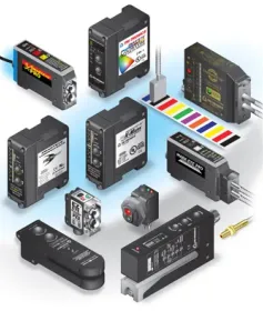 Assorted industrial sensors and control modules on a white background with rainbow color calibration strip