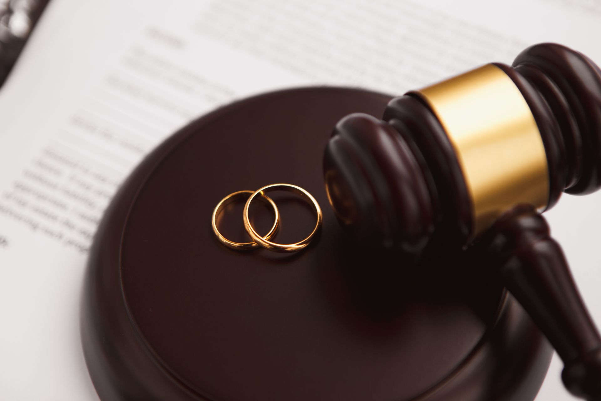 Gavel and wedding rings on a legal document representing professional divorce lawyer services.