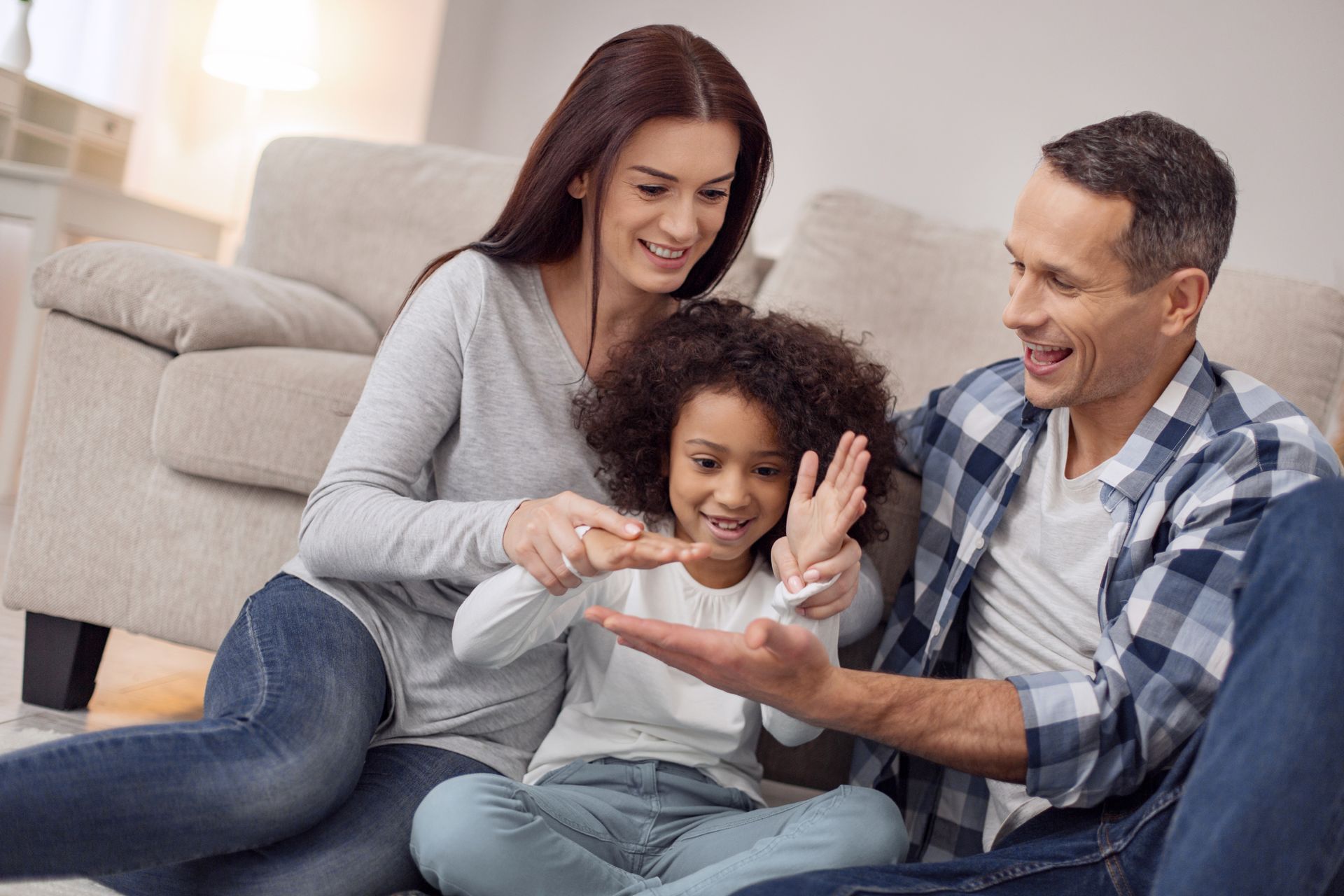 Smiling parents playing with their daughter at home Smiling parents playing with their daughter at home