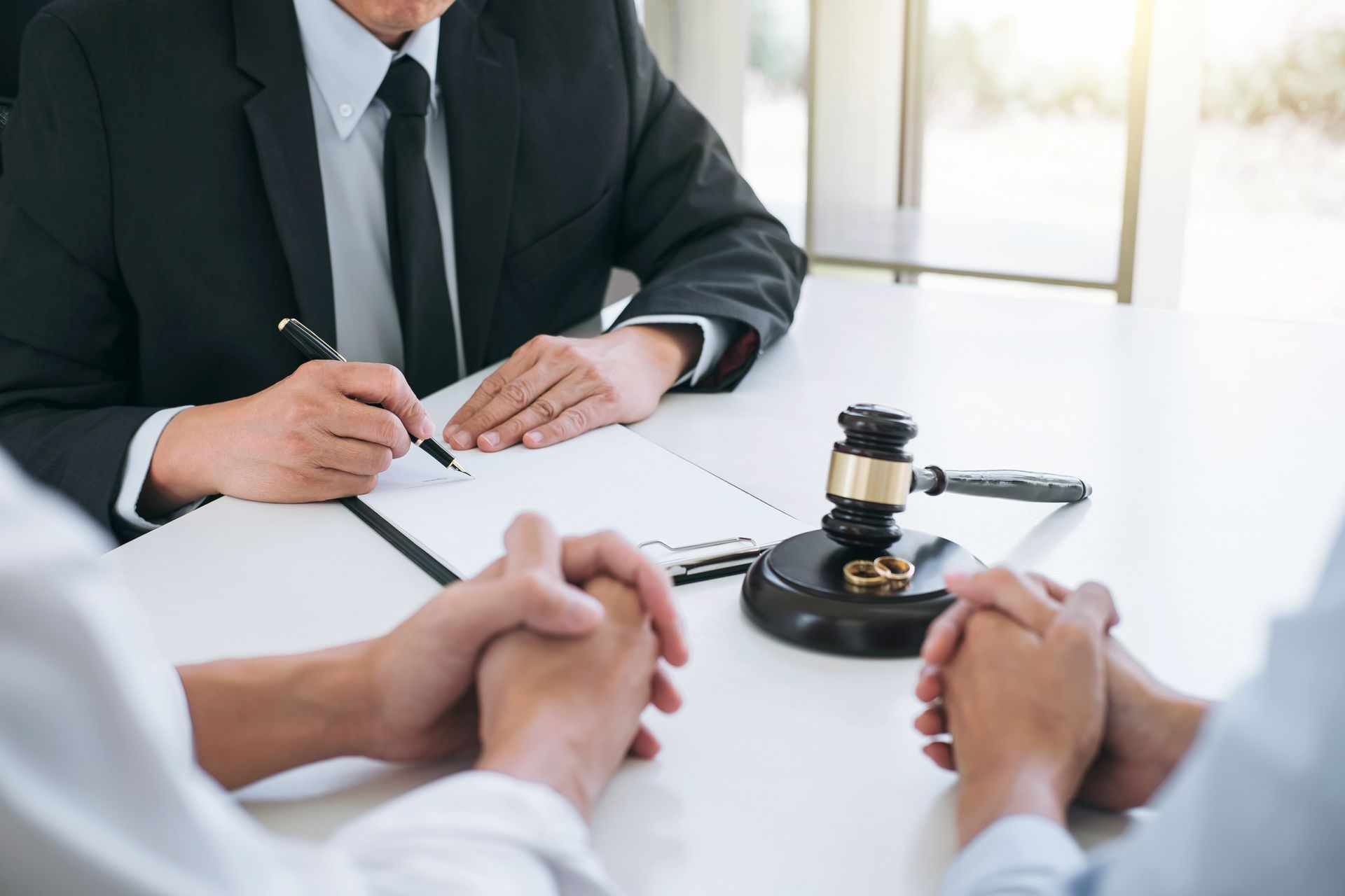 Close-up of a gavel and rings during a consultation for expert divorce lawyer services and advice.