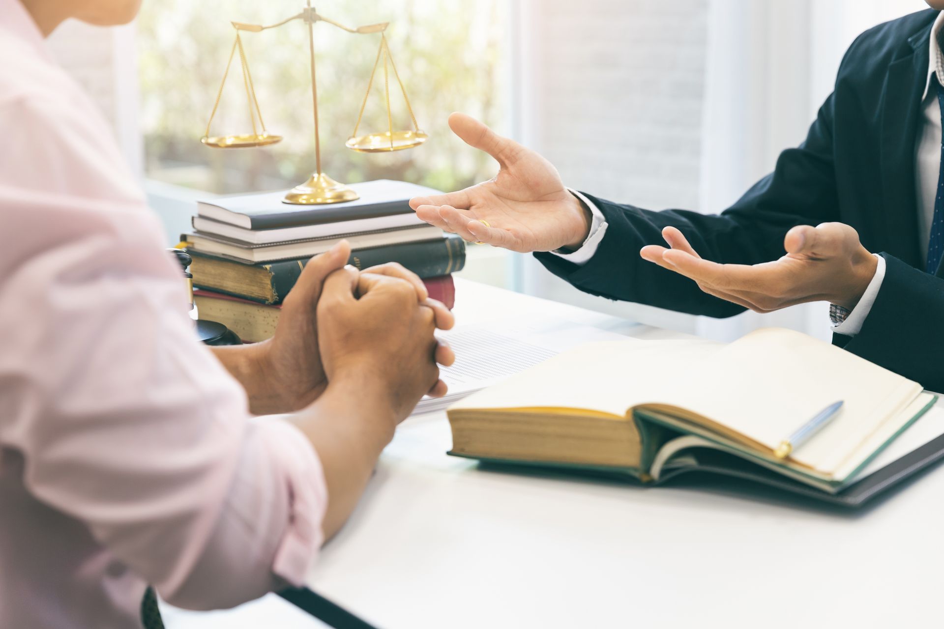 Attorney consulting with a client at a law office desk, discussing legal options.