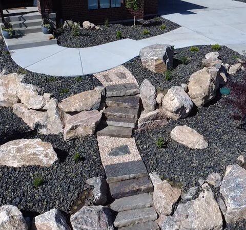 Rock garden with a narrow stepping-stone path leading to a house patio