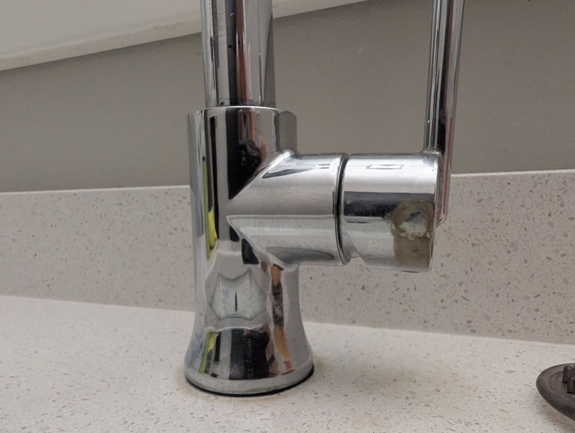 Shiny chrome kitchen faucet on white countertop.