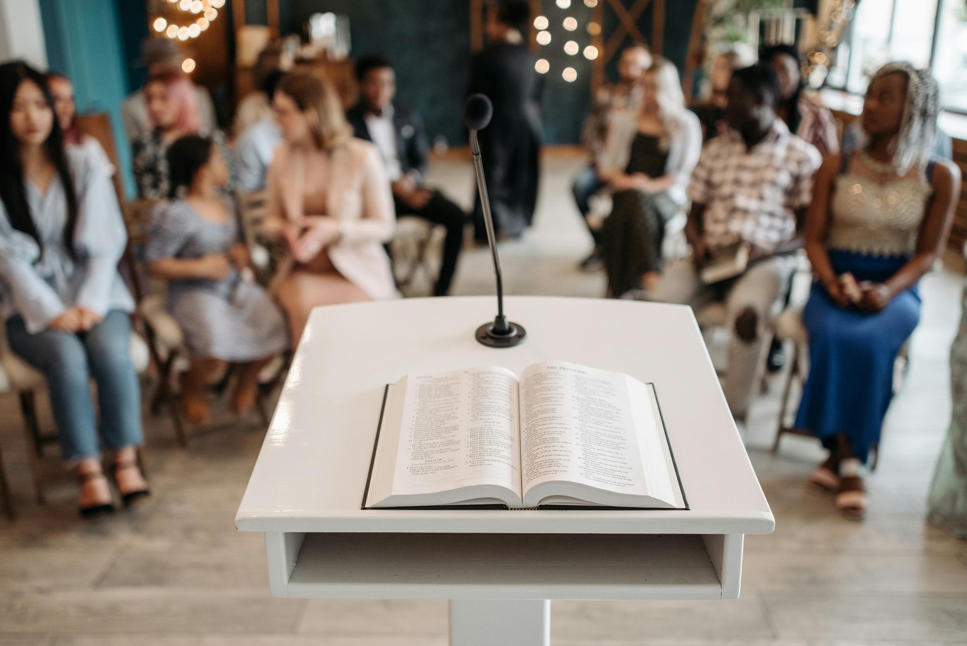 An open book is on a table in front of a window