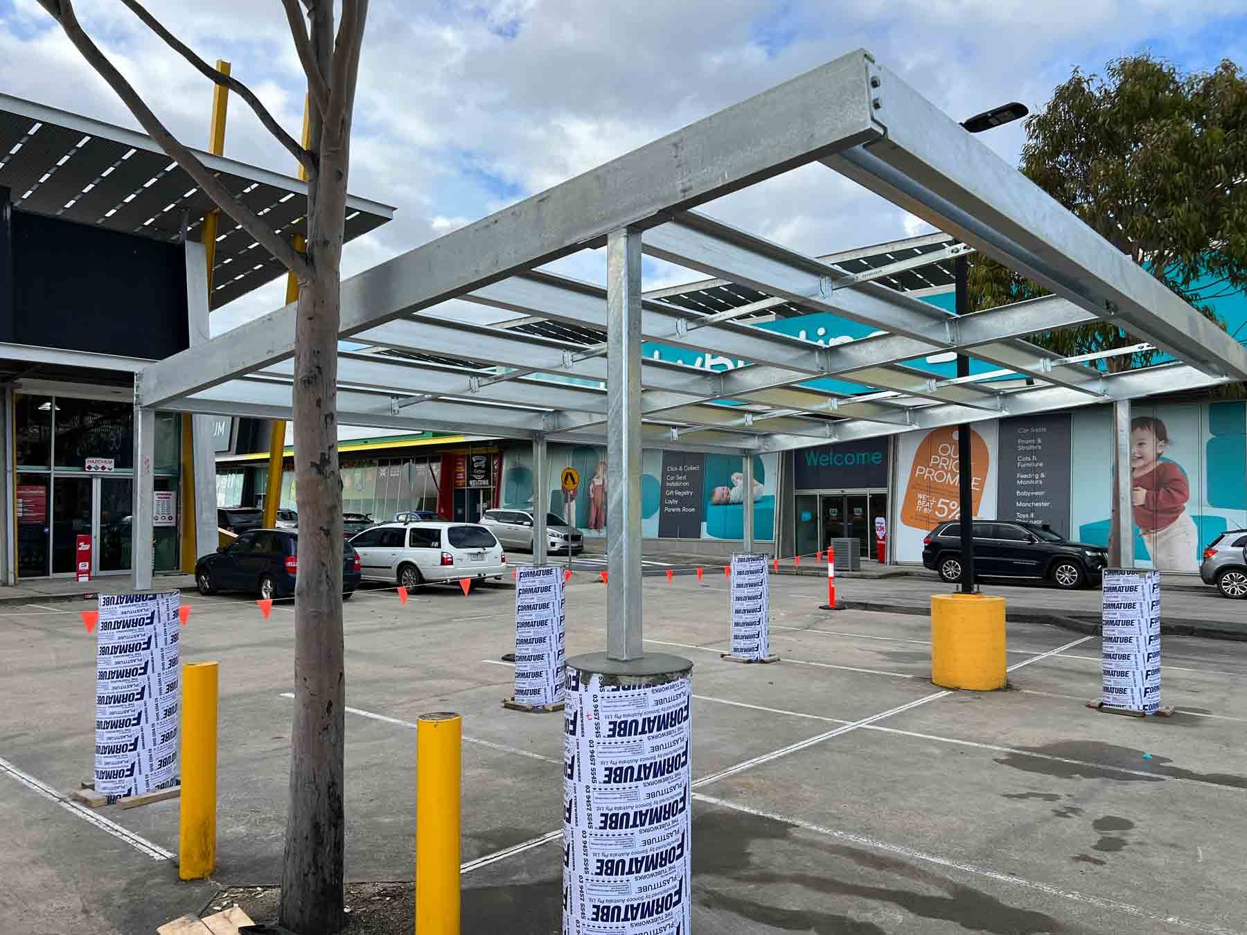A parking lot with cars parked under a canopy