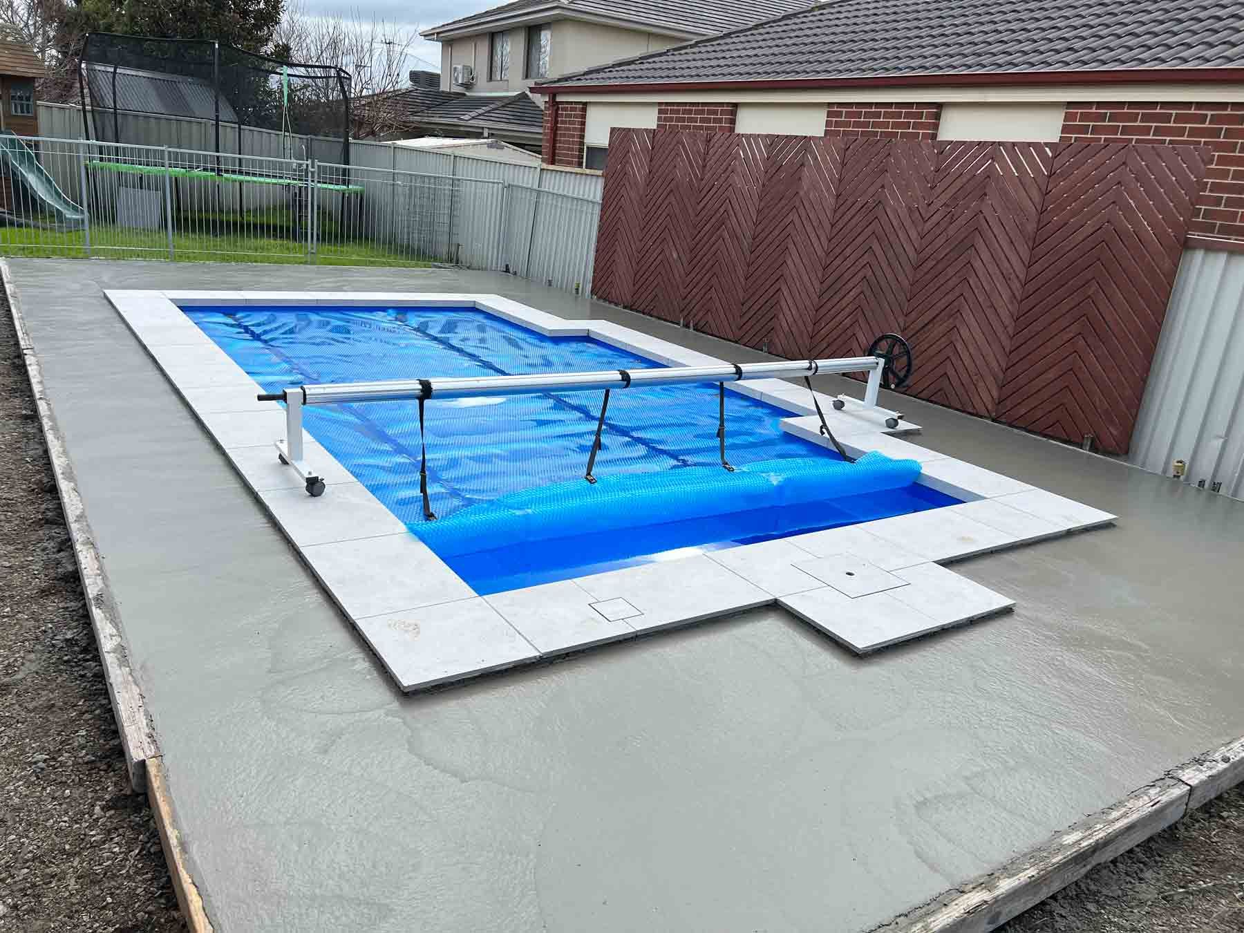 A swimming pool is being built in the backyard of a house