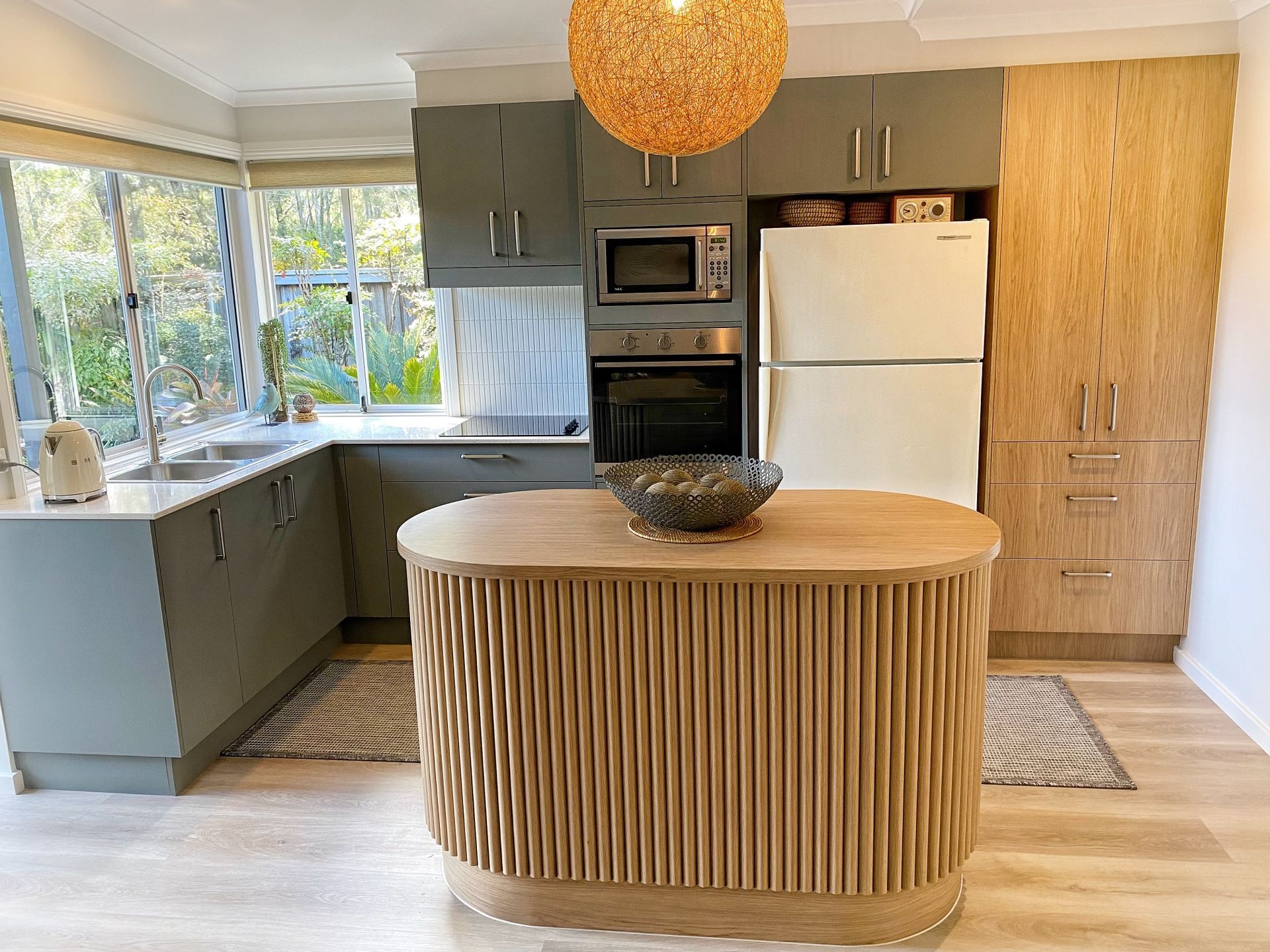 Modern kitchen with curved island — Piscopo Kitchens Plus In Forster, NSW