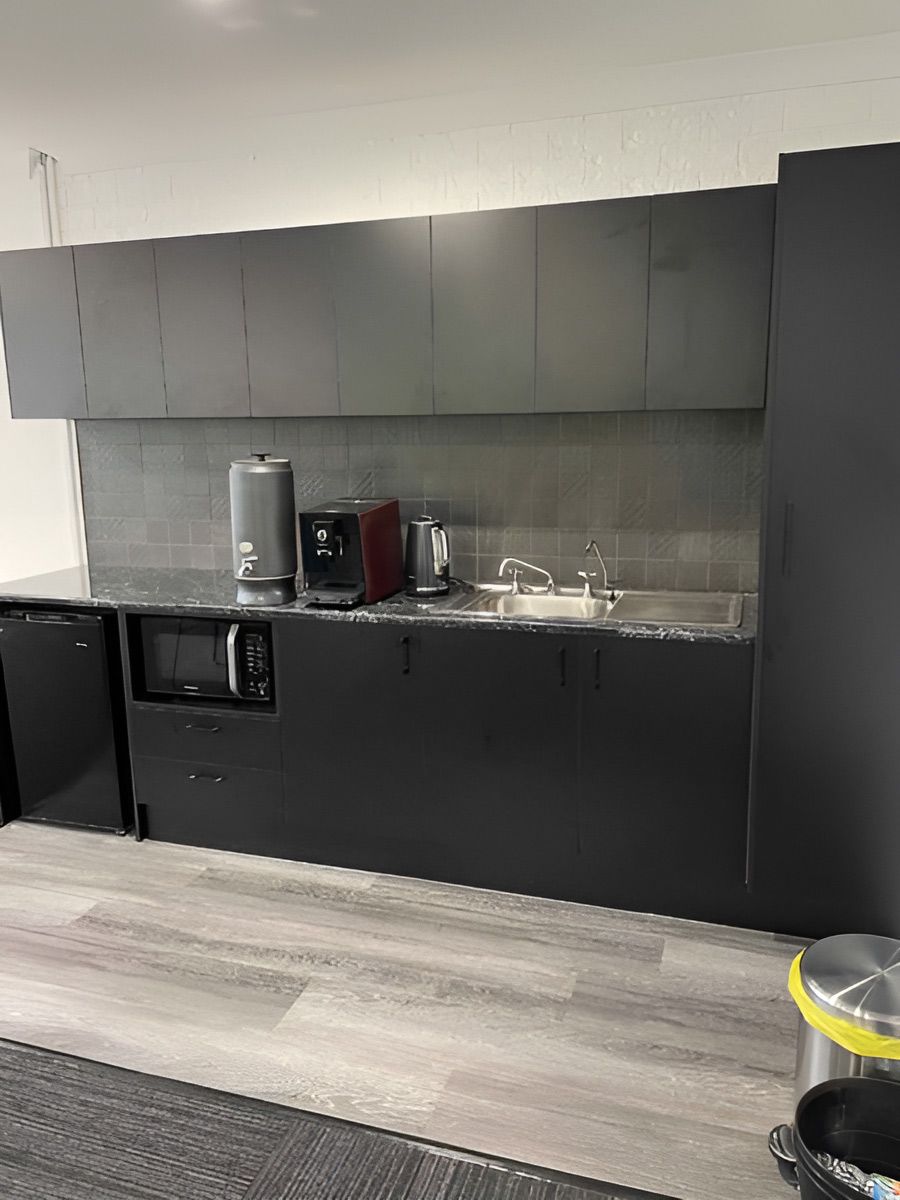 Kitchen Area With Dark Cabinetry and a Metal Sink — Piscopo Kitchens Plus In Forster, NSW