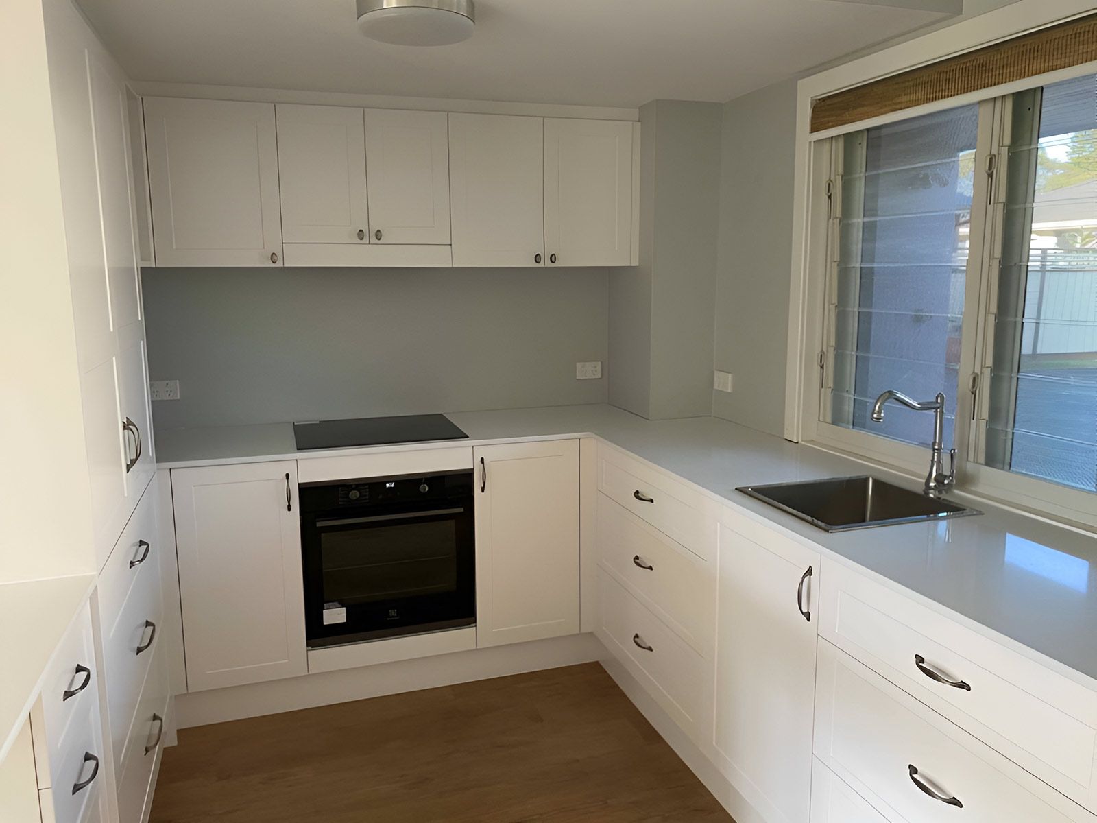 Kitchen With White Cabinets and Sleek Black Appliances — Piscopo Kitchens Plus In Forster, NSW