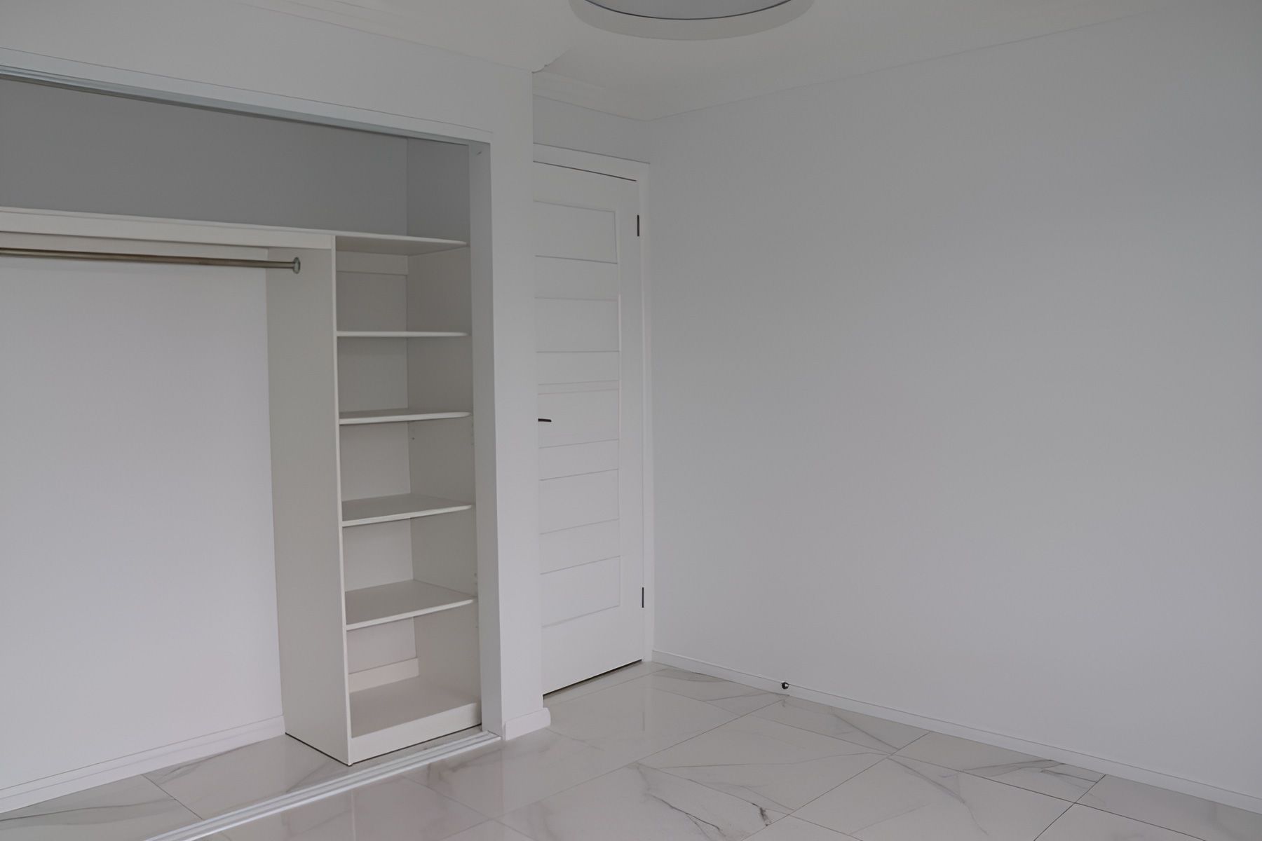 Empty White Room Featuring a Closet With Shelves — Piscopo Kitchens Plus In Forster, NSW