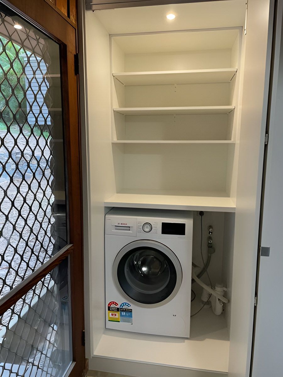 A White Washing Machine Beneath Open White Shelves — Piscopo Kitchens Plus In Forster, NSW