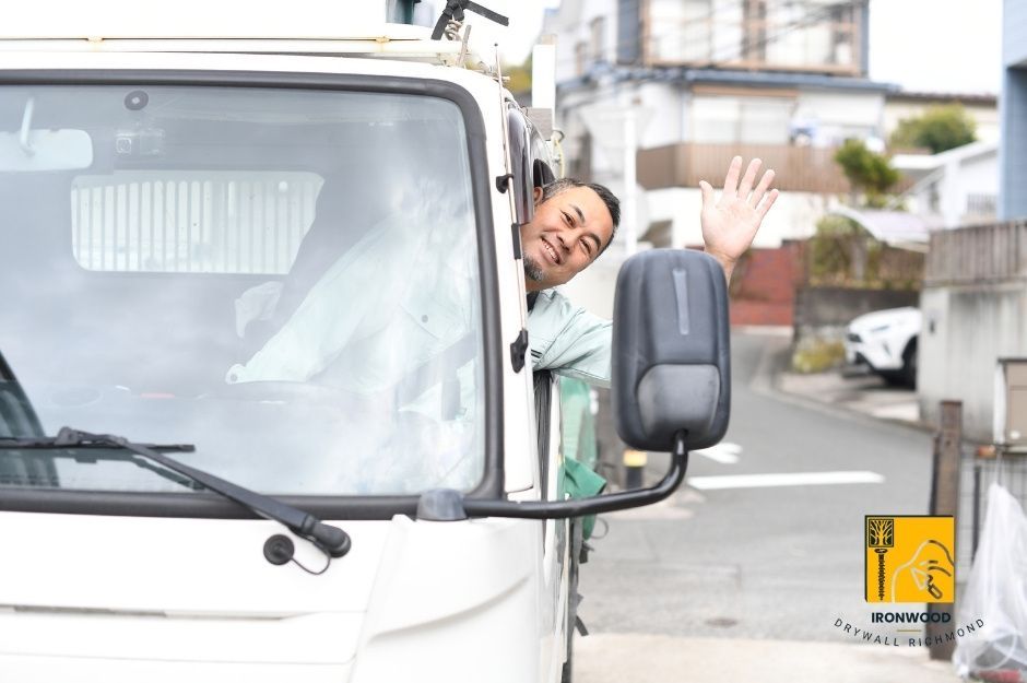 A professional drywall contractor delivering sheetrock to a home in a work van.
