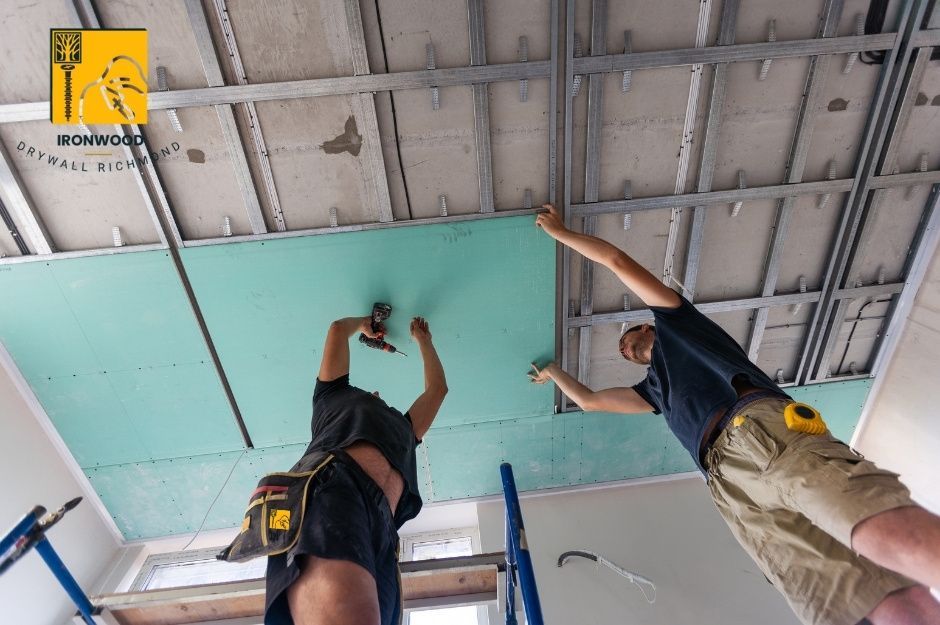 Two Steveston North neighborhood contractors installing drywall on a ceiling in Richmond BC.