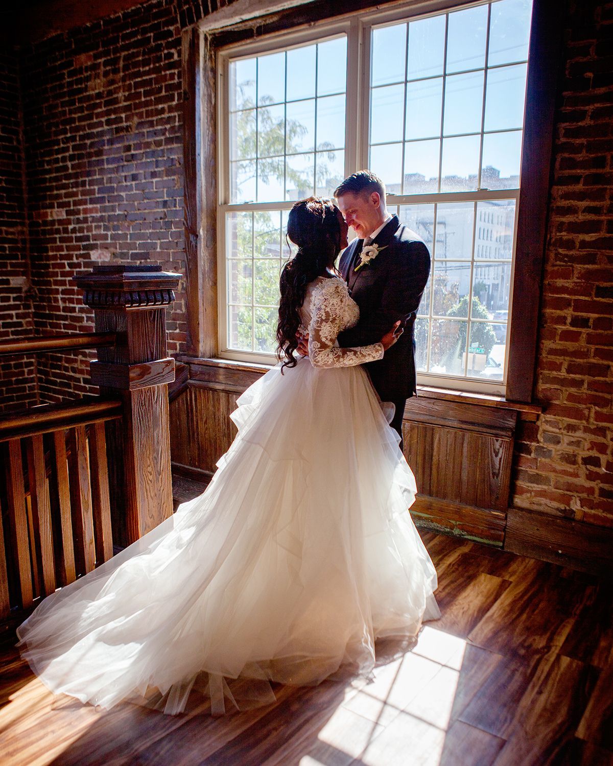 bride and groom embracing on wooden stairwell