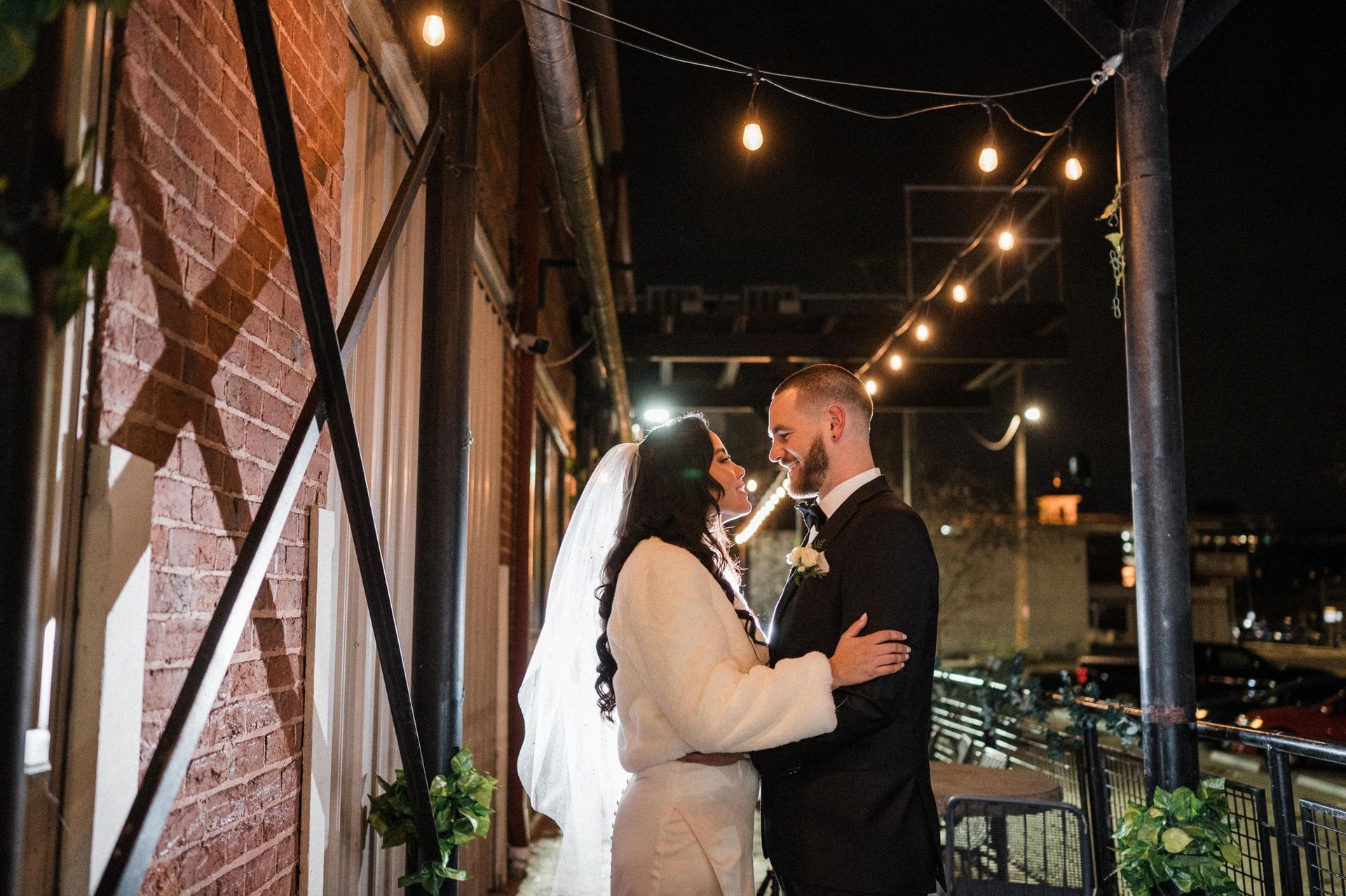 couple embracing under bistro lights on patio