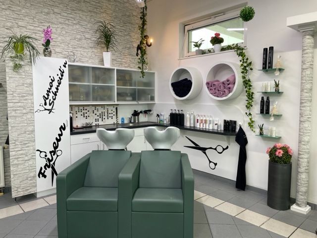 Ein Friseursalon mit zwei Stühlen und einem Waschbecken