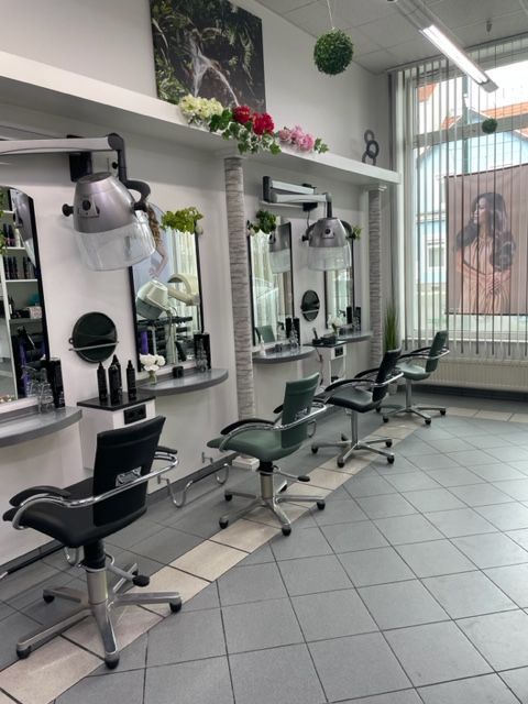 Ein Friseursalon mit vielen Stühlen und Spiegeln