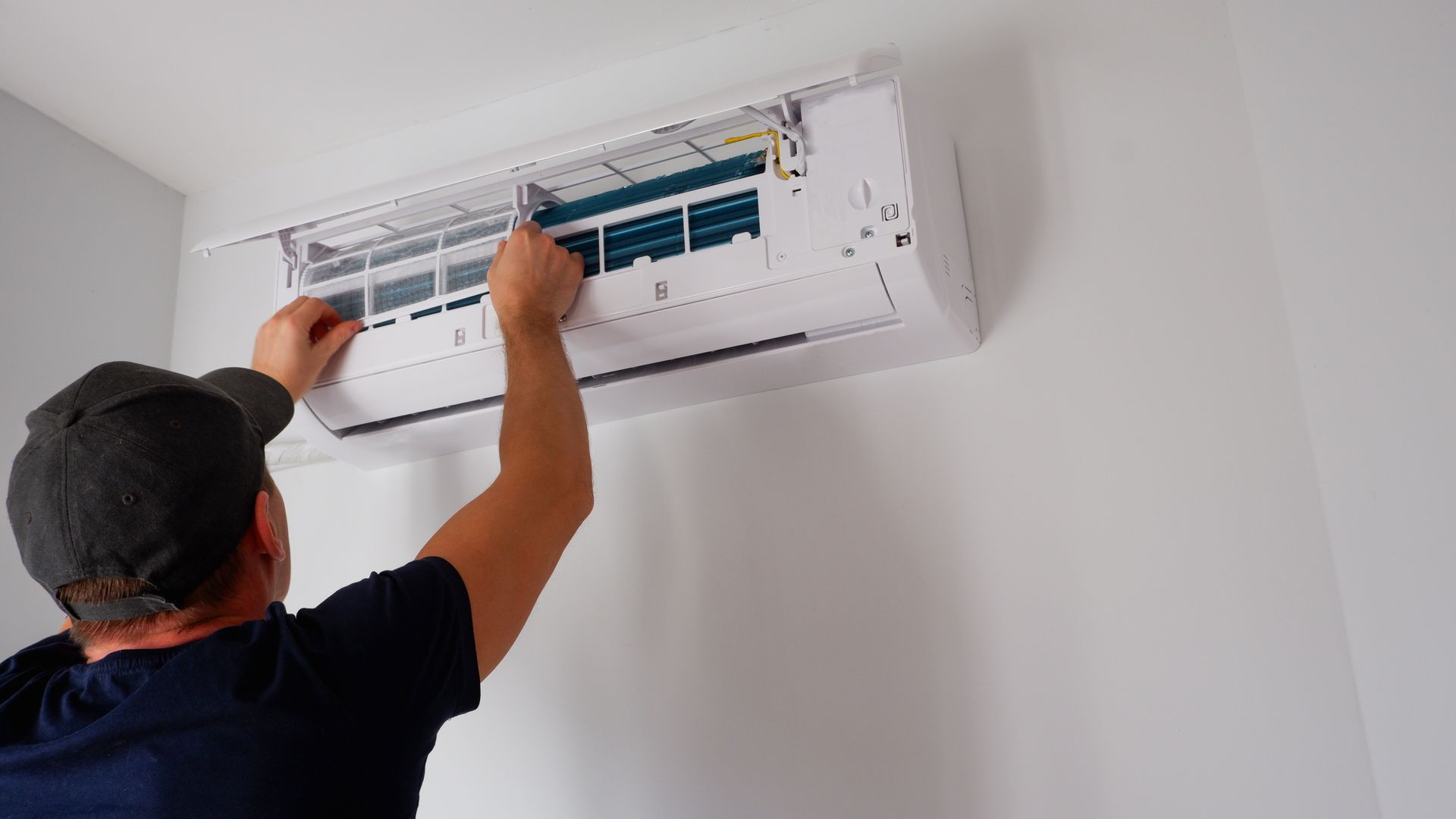 A man is working on an AC.