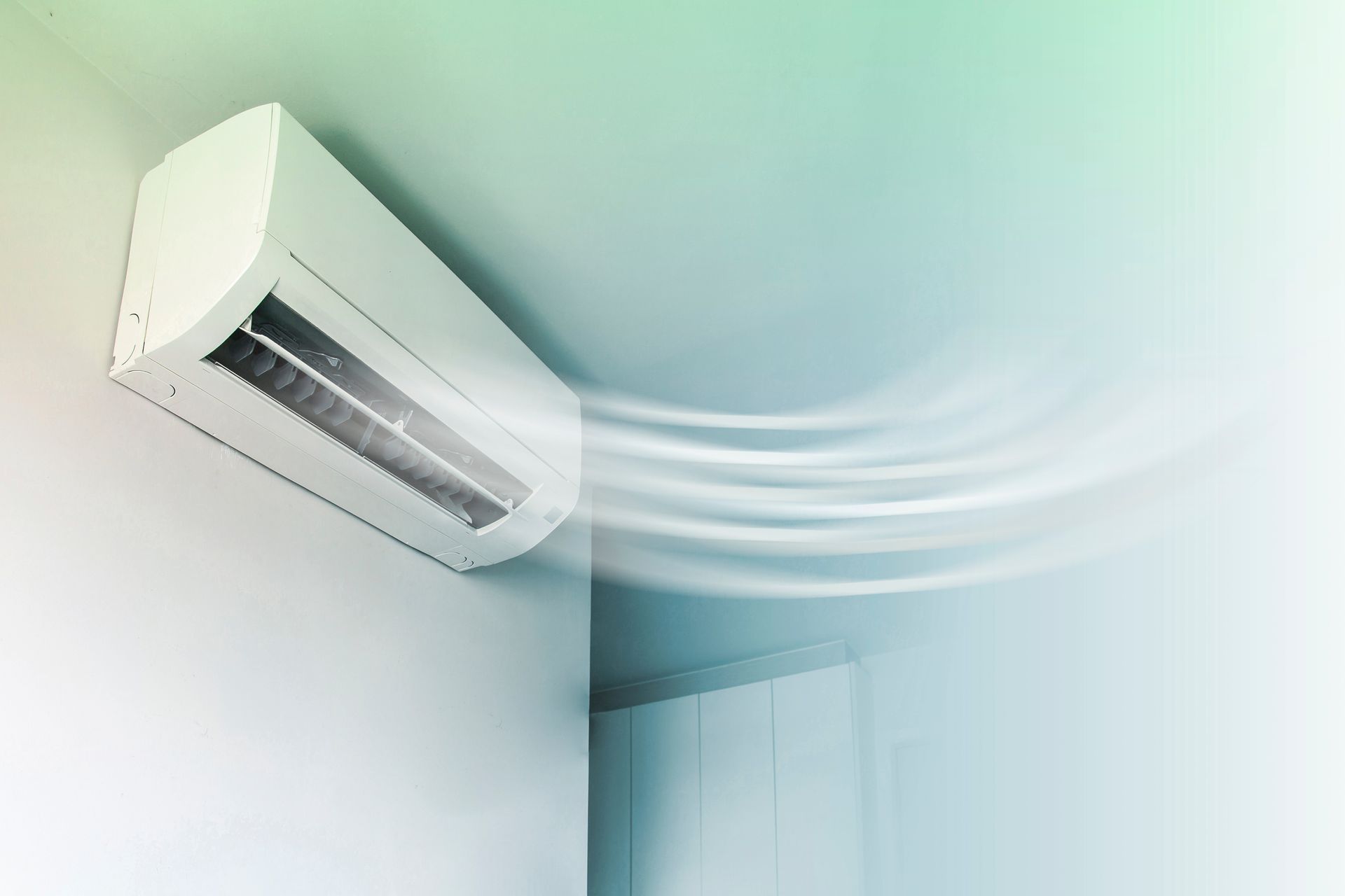 Wall-mounted air conditioner blowing cool air into a white room.