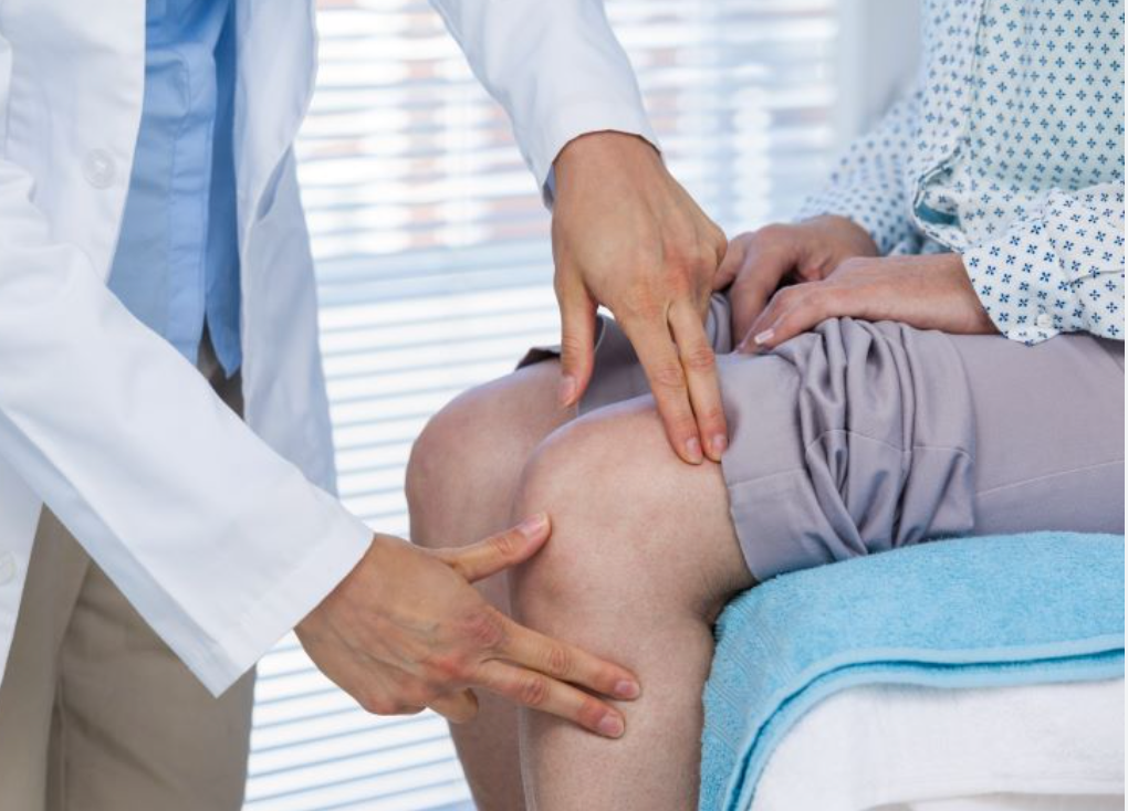 Doctor examining a patient’s knee during a medical appointment