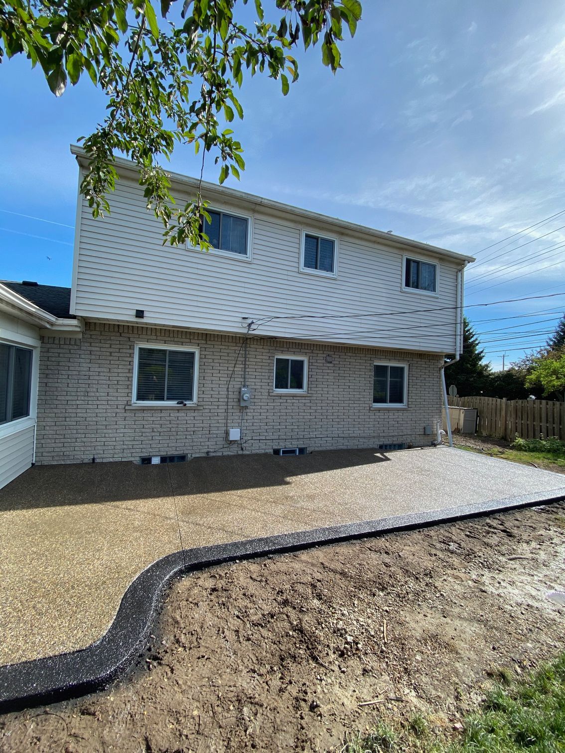 A large white house with a gravel driveway in front of it.