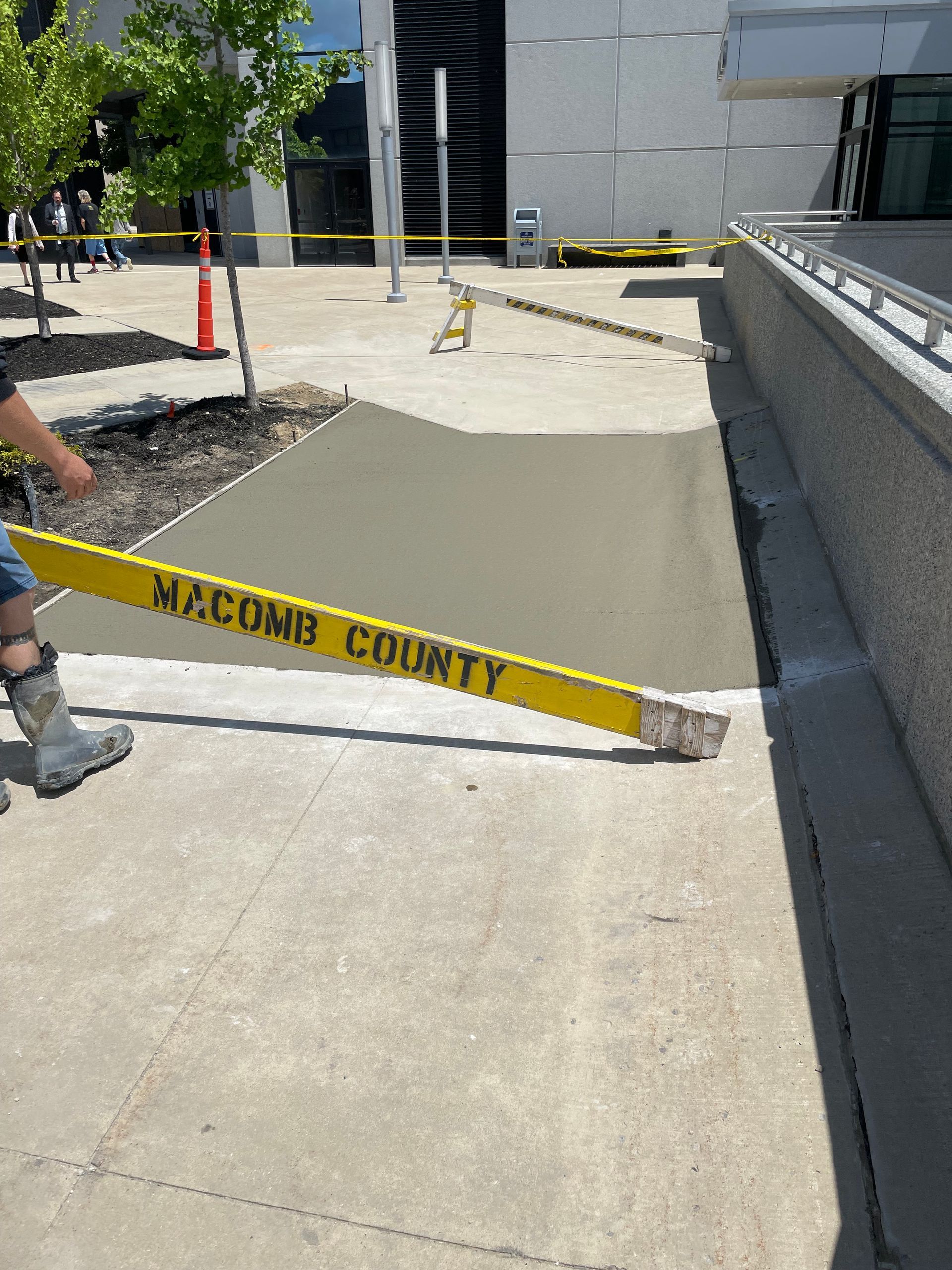 A person is holding a yellow tape that says macomb county on it.
