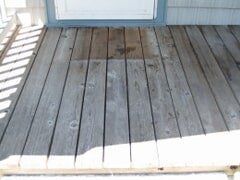 Wooden deck in front of a white door. 