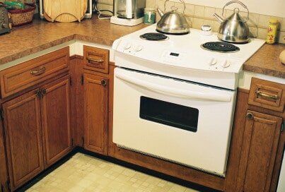 Kitchen corner with a white oven and brown cabinets.