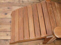 Wooden chair with curved back, constructed from vertical planks. 