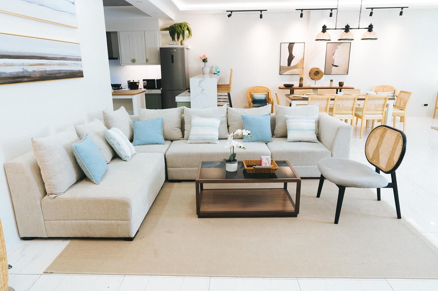 Living room with a beige sectional sofa, coffee table, and dining area.