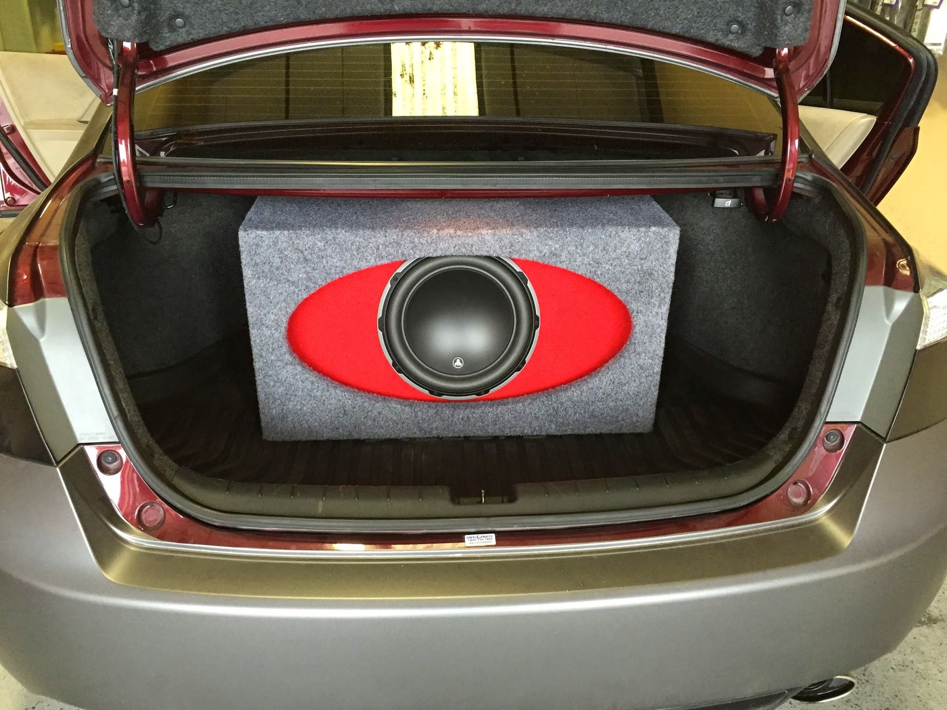 Open car trunk with a red-and-black speaker box mounted inside