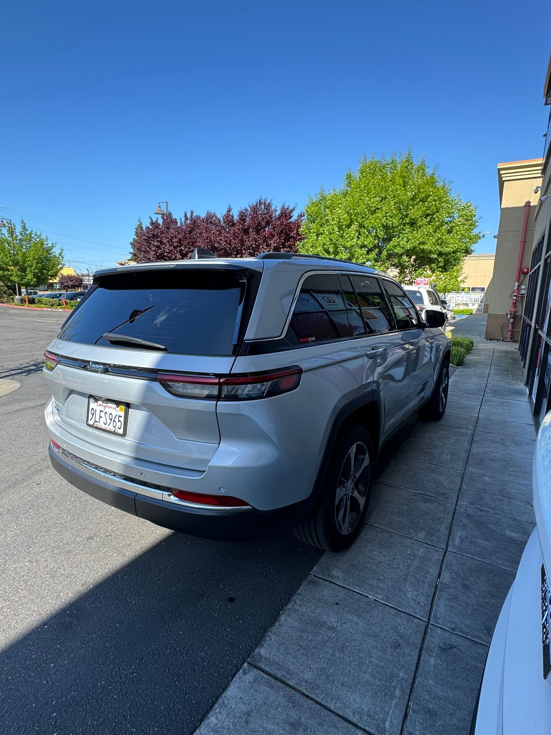 Silver SUV parked in a driveway beside a house under a clear blue sky