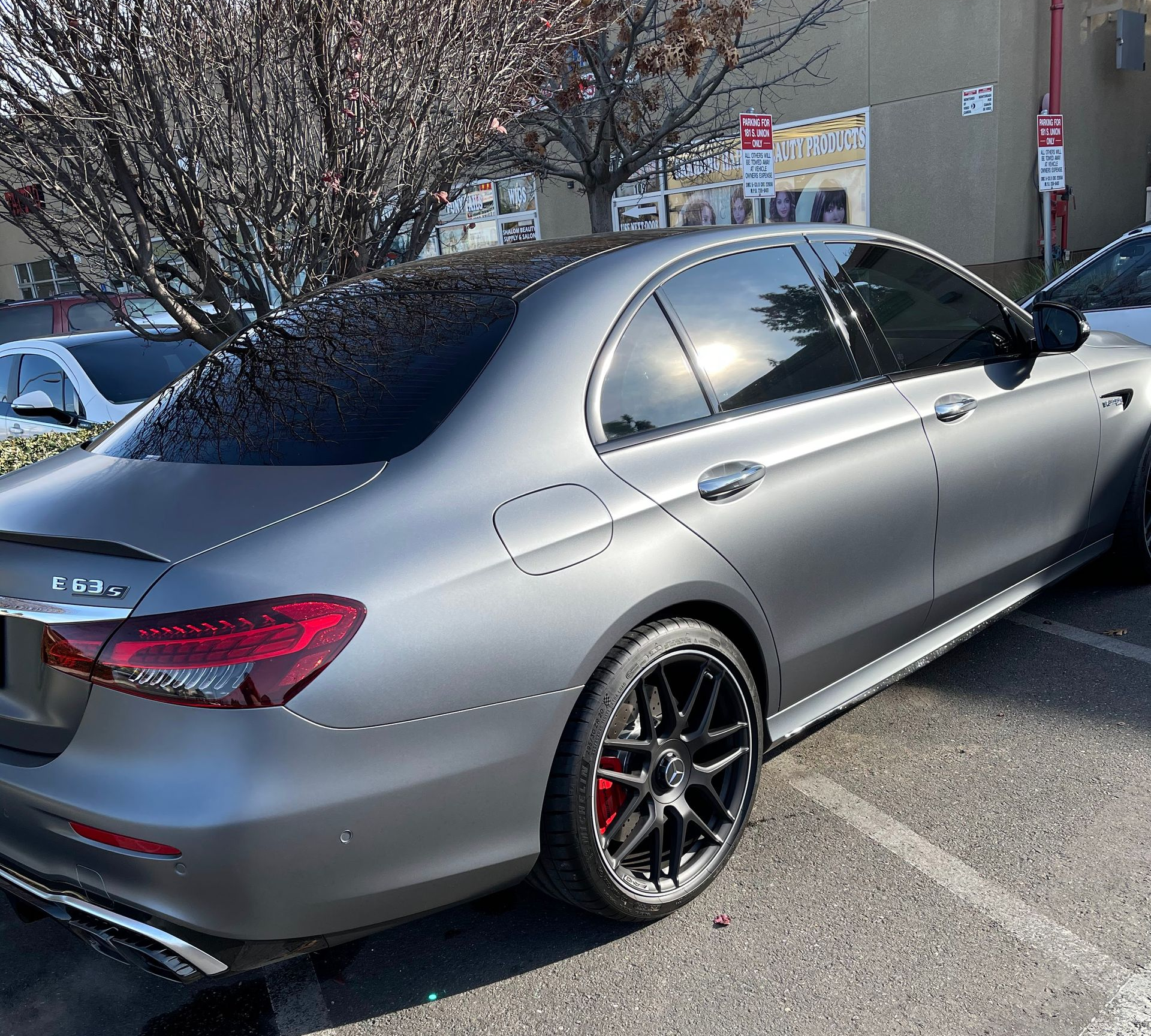 Silver Mercedes sedan parked in a lot, rear-side view with tinted windows and black rims