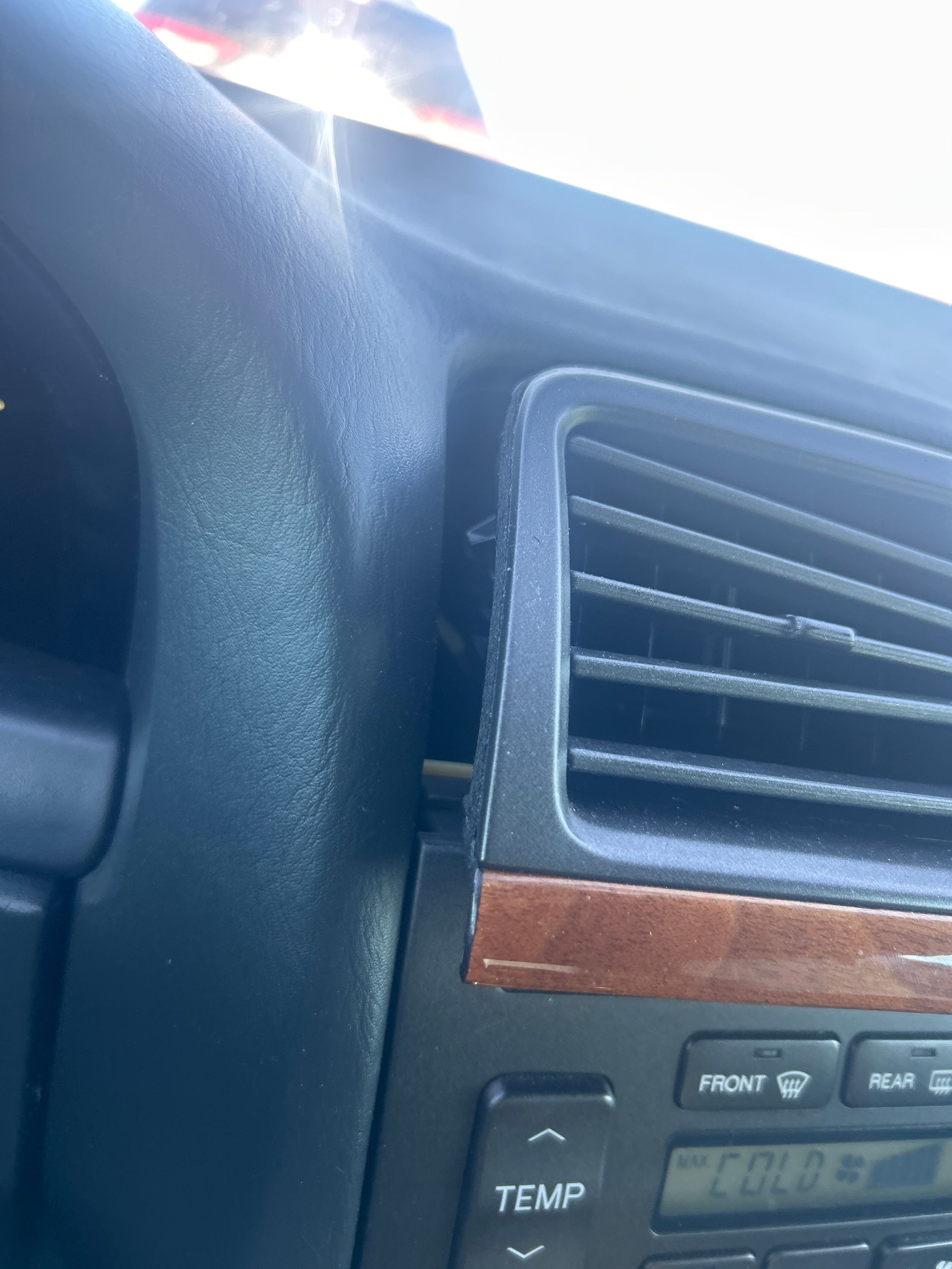 Close-up of a car dashboard with air vents and a digital display panel.