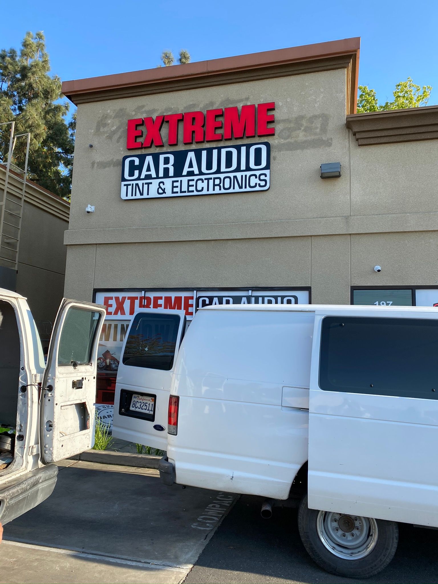 White van parked outside Extreme Car Audio and Tint & Electronics storefront