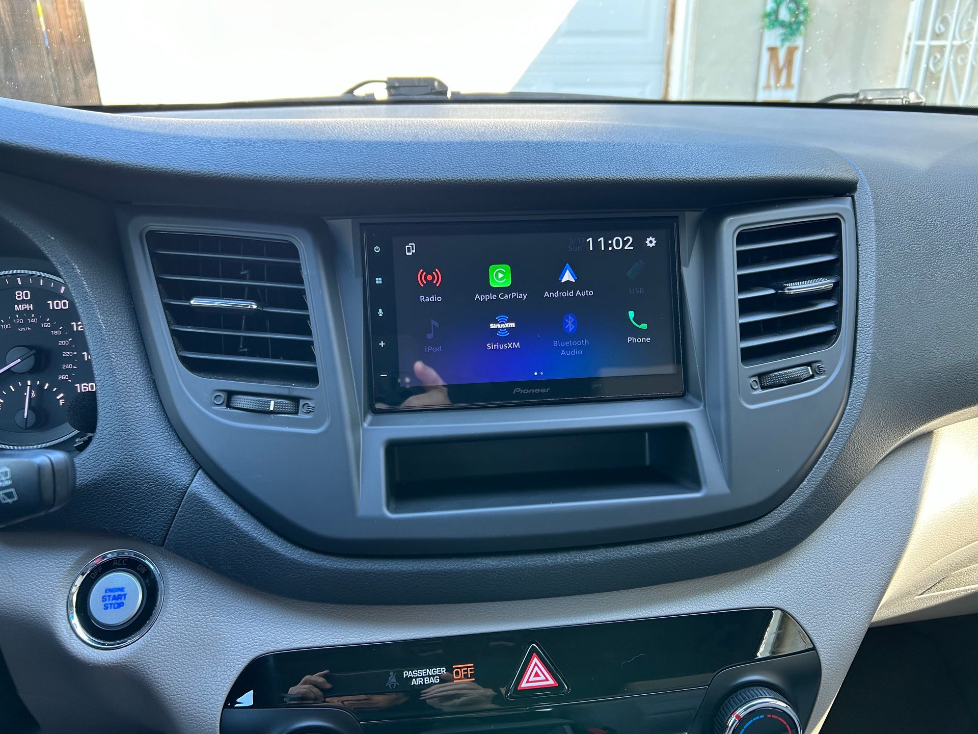 Car dashboard center console with infotainment screen, air vents, and hazard lights button displayed.