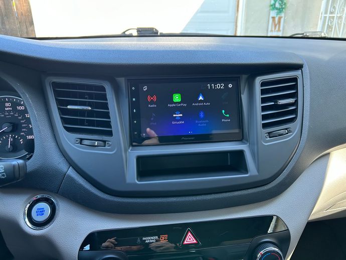Car dashboard center console with infotainment screen and air vents, viewed from the front seat
