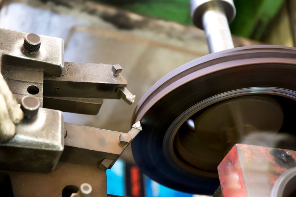 A Machine Lathe Tool Resurfacing a Rotating Metal Vehicle — Berkeley Vale Tyre & Mechanical in Fountaindale, NSW